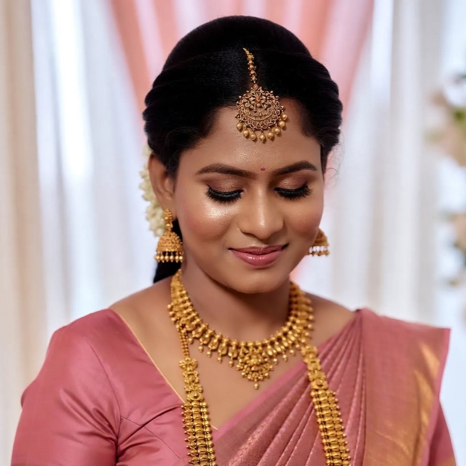 Woman in a pink saree with traditional gold jewellery
